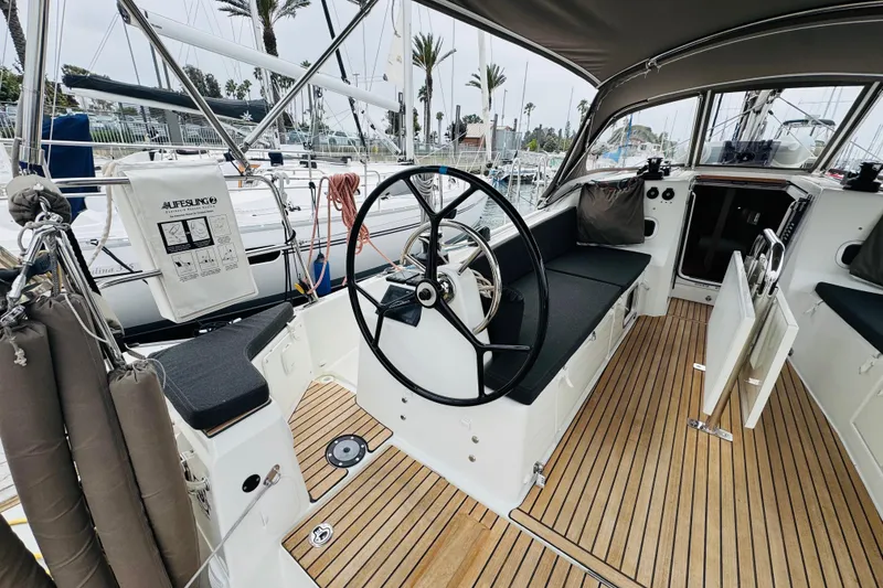 Slide: The Image of 2023 Jeanneau 380 yacht cockpit with steering wheel and teak flooring. - 10