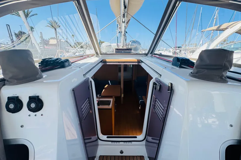 Slide: The Image of 2023 Jeanneau 380 sailboat cockpit with open cabin doors, marina view. - 13