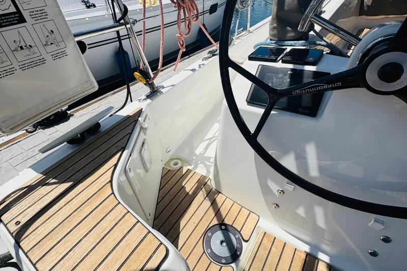 Slide: The Image of Cockpit of 2023 Jeanneau 380 sailboat with steering wheel and wooden deck. - 16