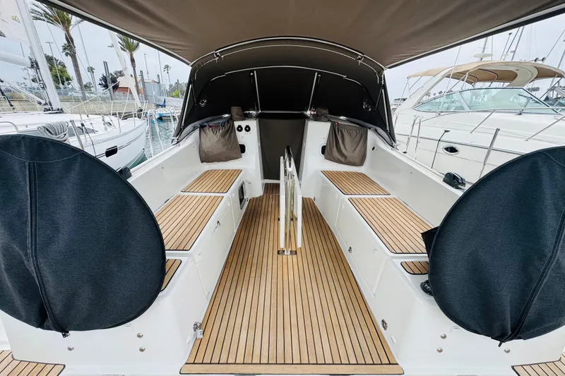 Slide: The Image of 2023 Jeanneau 380 yacht cockpit with teak flooring and covered steering wheels. - 18