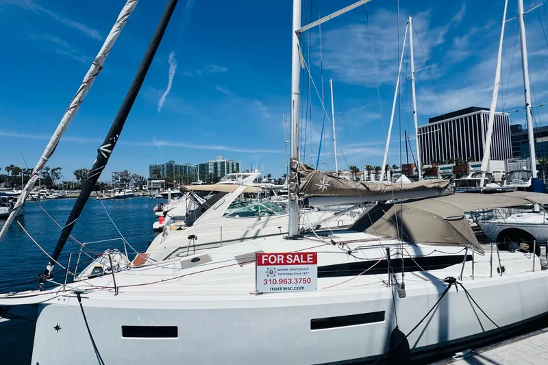 Slide: The Image of 2023 Jeanneau 380 sailboat for sale docked at marina under clear blue sky. - 2