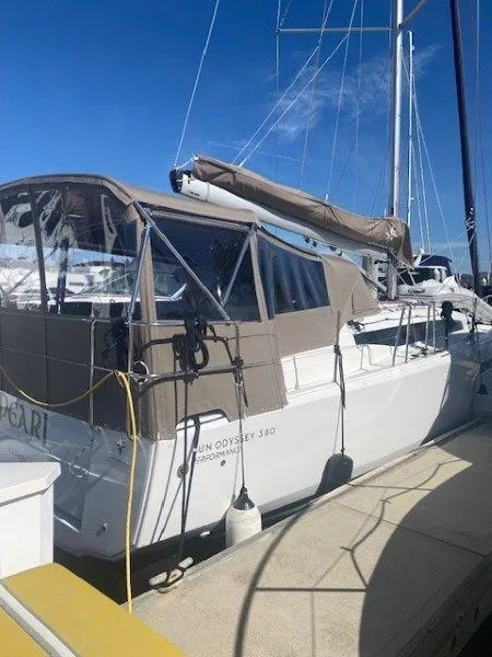 Slide: The Image of 2023 Jeanneau 380 sailboat docked, featuring a covered cockpit and sleek design. - 25