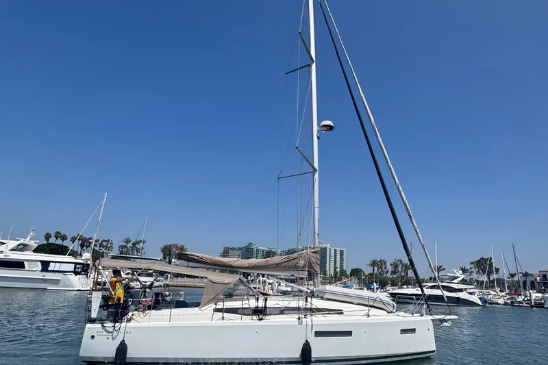 Slide: The Image of 2023 Jeanneau 380 sailboat docked in a marina under clear blue skies. - 3
