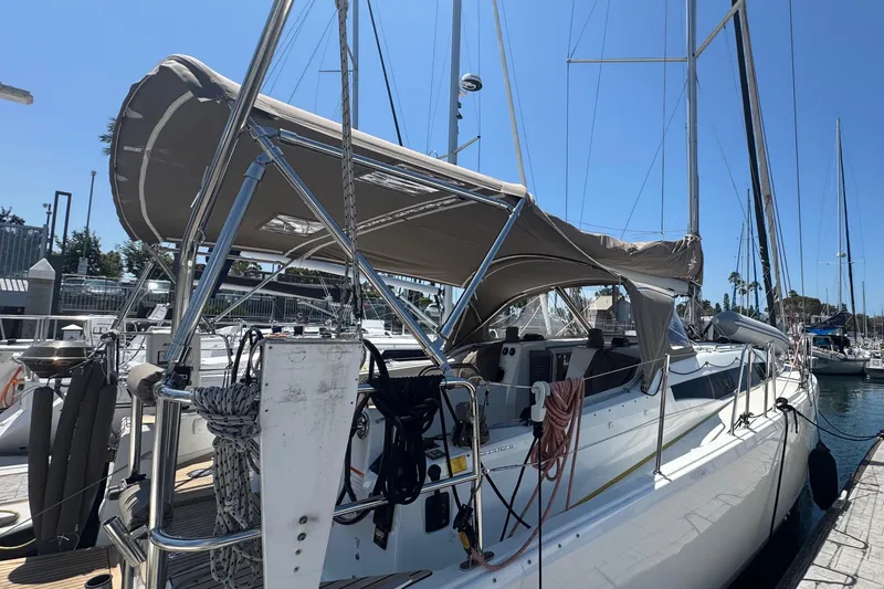 Slide: The Image of 2023 Jeanneau 380 sailboat docked at marina, featuring a sleek design and sunshade canopy. - 30