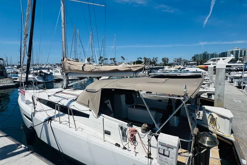 Slide: The Image of 2023 Jeanneau 380 sailboat docked at a marina under a clear blue sky. - 32