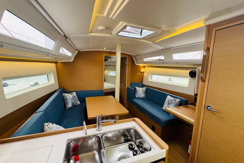 Slide: The Image of 2023 Jeanneau 380 yacht interior with modern kitchen, seating, and natural light. - 43