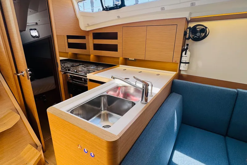 Slide: The Image of Modern kitchen interior of 2023 Jeanneau 380 yacht with sink, stove, and seating area. - 44