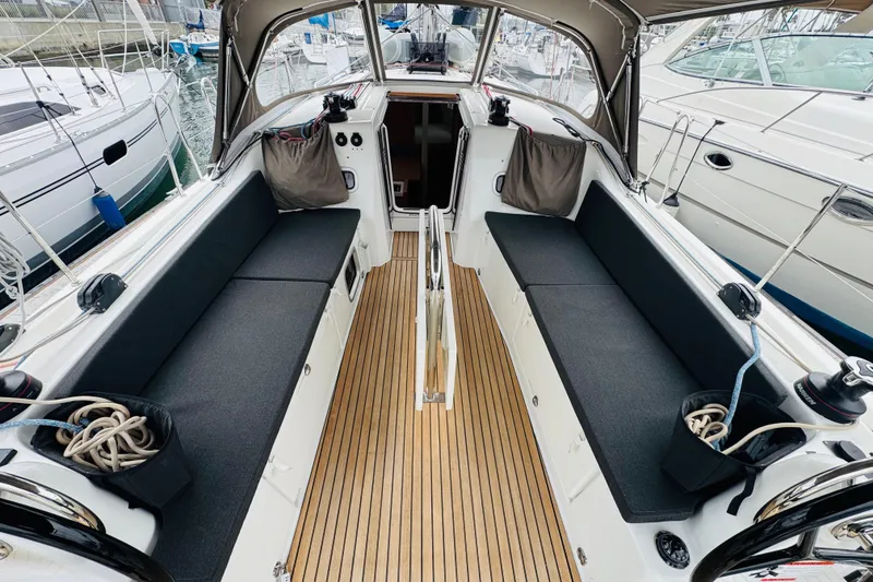 Slide: The Image of 2023 Jeanneau 380 sailboat cockpit with teak flooring and cushioned seating. - 6
