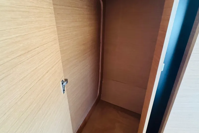 Slide: The Image of Interior storage space on 2023 Jeanneau 380 yacht, featuring wooden finish and door latch. - 60