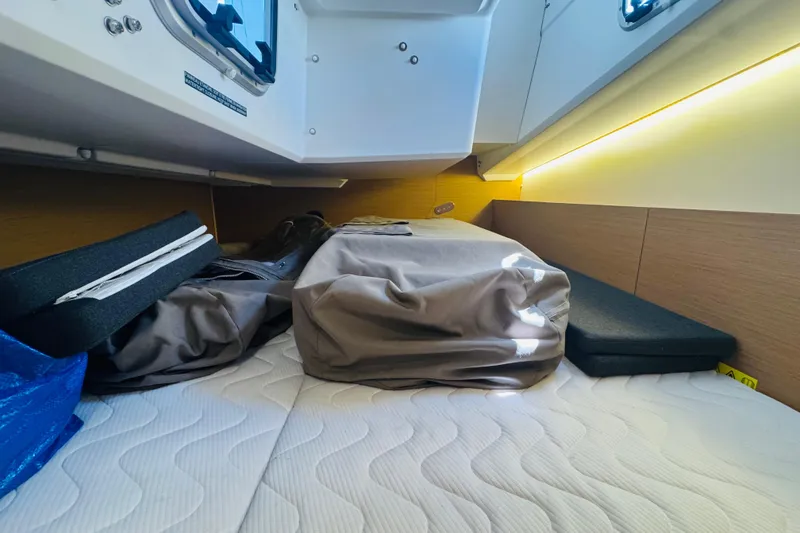 Slide: The Image of 2023 Jeanneau 380 cabin interior with storage and bedding, featuring modern design and lighting. - 64