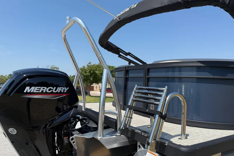 Slide: The Image of 2025 Flagship F22CU SPORT TOON boat with Mercury engine and ladder, under clear blue sky. - 19