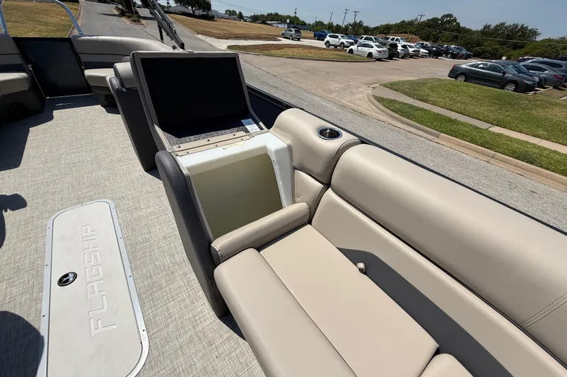 Slide: The Image of 2025 Flagship F22CU SPORT TOON boat interior with beige seating and built-in cooler. - 33
