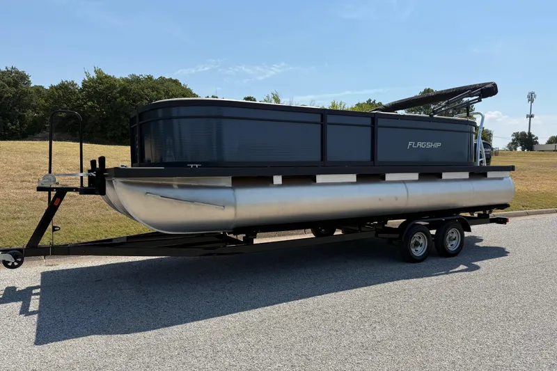 Slide: The Image of 2025 Flagship F22CU SPORT TOON pontoon boat on trailer, parked outdoors. - 5