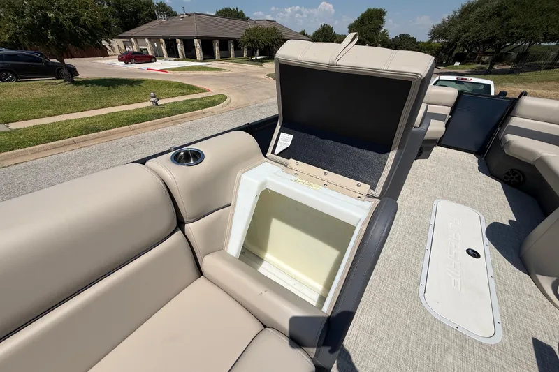 Slide: The Image of 2025 Flagship F22CU SPORT TOON boat interior with open storage compartment and beige seating. - 54