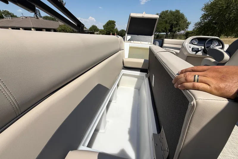 Slide: The Image of 2025 Flagship F22CU SPORT TOON boat interior with open storage compartment and dashboard view. - 55