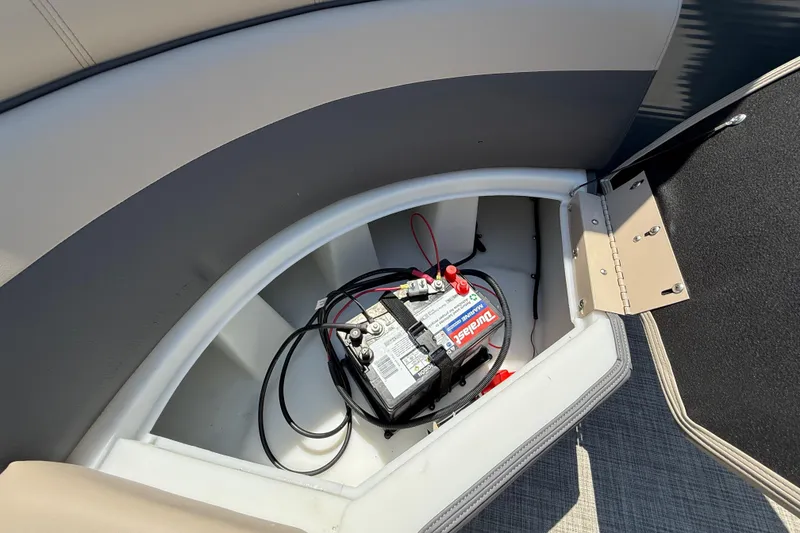 Slide: The Image of Battery compartment of 2025 Flagship F22CU SPORT TOON boat, featuring a marine battery. - 57