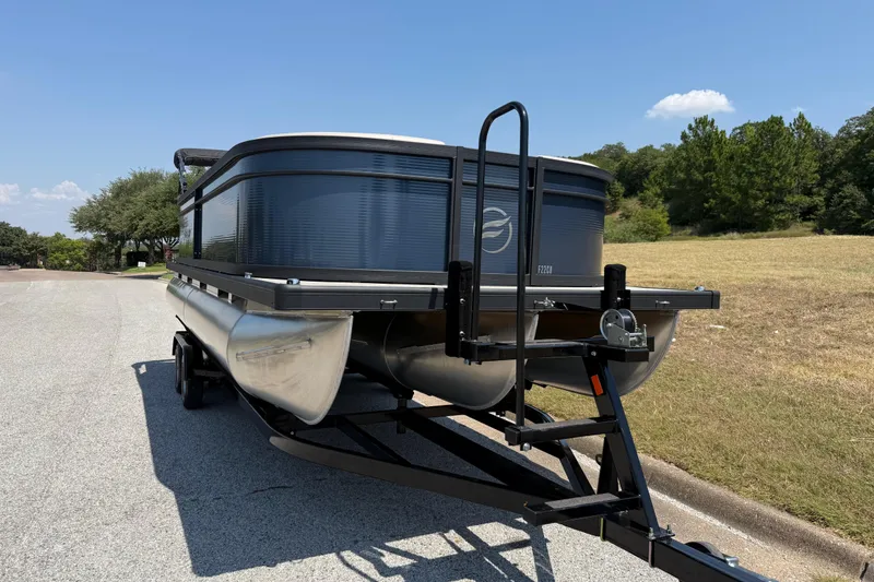 Slide: The Image of 2025 Flagship F22CU SPORT TOON pontoon boat on trailer, parked on a sunny road. - 64