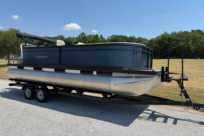 Slide: The Image of 2025 Flagship F22CU SPORT TOON pontoon boat on trailer, parked outdoors. - 67