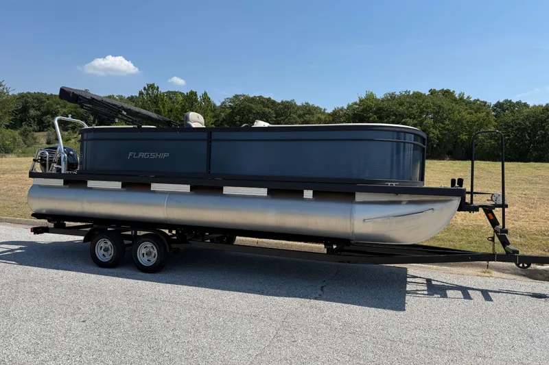 Slide: The Image of 2025 Flagship F22CU SPORT TOON pontoon boat on trailer, parked outdoors. - 68