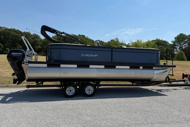 Slide: The Image of 2025 Flagship F22CU SPORT TOON pontoon boat on trailer, parked outdoors. - 71