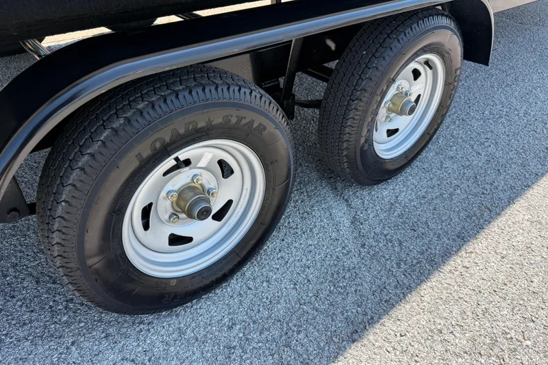 Slide: The Image of Dual wheels of 2025 Flagship F22CU SPORT TOON trailer on asphalt surface. - 76