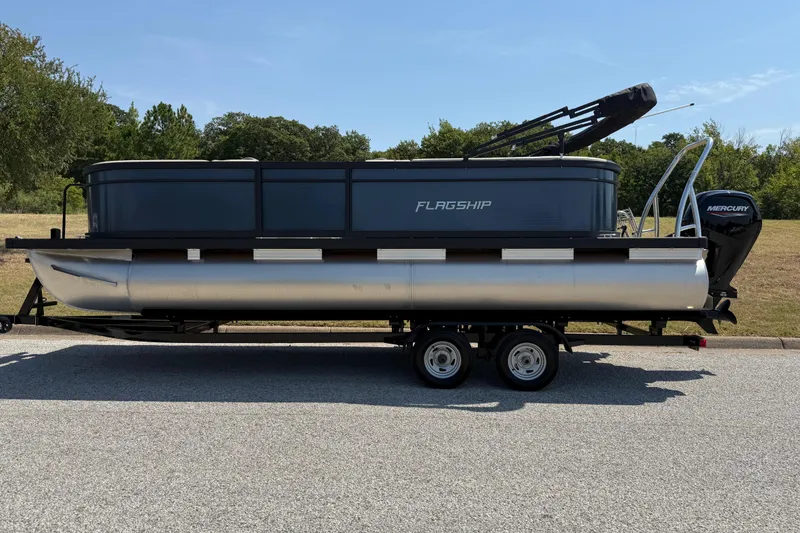 Slide: The Image of 2025 Flagship F22CU SPORT TOON pontoon boat on trailer, parked outdoors. - 8