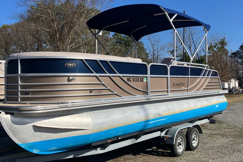 The Image of 2013 South Bay 724 pontoon boat on trailer, blue canopy, parked outdoors. - 1