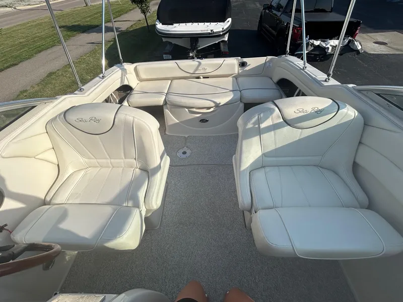Slide: The Image of 2004 Sea Ray 225 Weekender boat interior with white seating and open deck layout. - 14