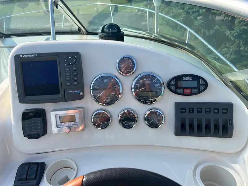 Slide: The Image of 2004 Sea Ray 225 Weekender dashboard with gauges, Lowrance GPS, and Clarion audio controls. - 16