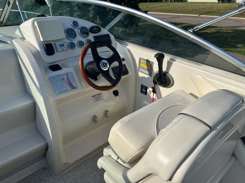 Slide: The Image of 2004 Sea Ray 225 Weekender boat cockpit with steering wheel and control panel. - 17