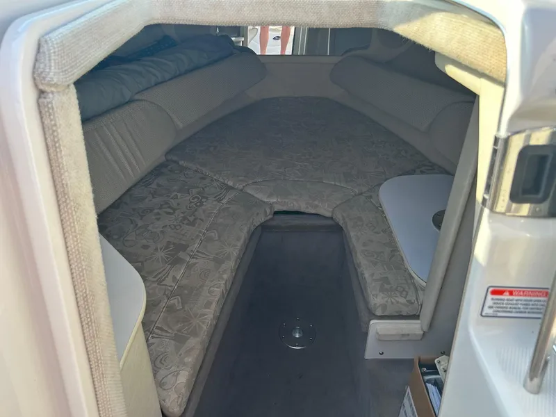 Slide: The Image of 2004 Sea Ray 225 Weekender cabin interior with cushioned seating and compact design. - 18