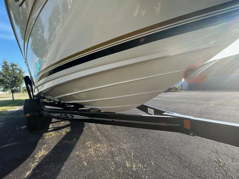 Slide: The Image of 2004 Sea Ray 225 Weekender boat on trailer, parked outdoors in sunlight. - 26