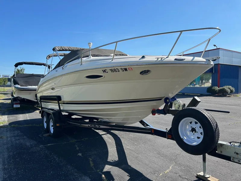 Slide: The Image of 2004 Sea Ray 225 Weekender boat on trailer, parked outdoors under clear blue sky. - 3