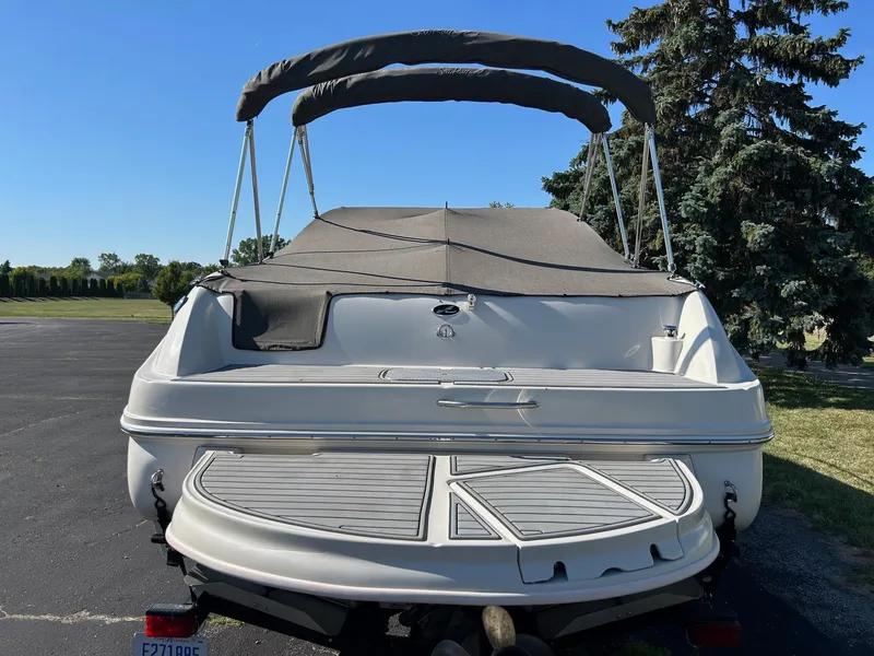 Slide: The Image of 2004 Sea Ray 225 Weekender boat with canopy, parked outdoors on a sunny day. - 5
