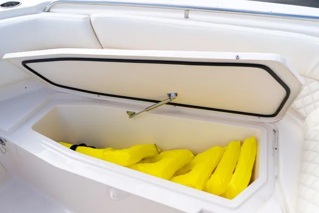 Slide: The Image of Open storage compartment on 2024 Grady-White Freedom 307 boat with yellow life jackets. - 40