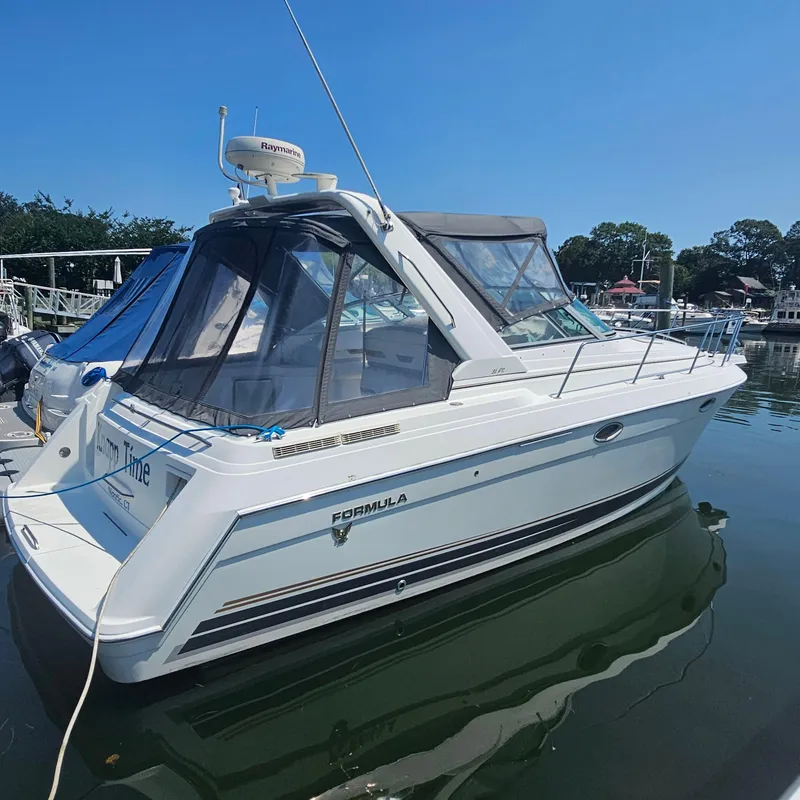 The Image of 2000 Formula 31 PC boat docked in a marina under clear blue skies. - 1