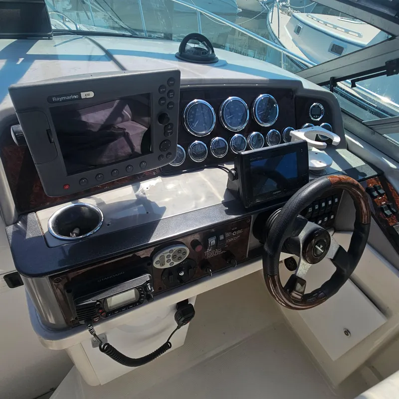 Slide: The Image of Control panel of a 2000 Formula 31 PC boat with navigation equipment and steering wheel. - 12