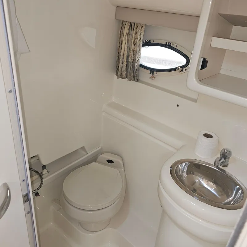 Slide: The Image of Compact bathroom in 2000 Formula 31 PC boat with toilet, sink, and porthole window. - 25