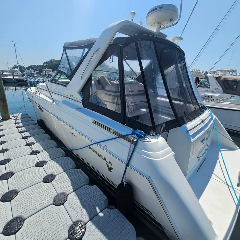 Slide: The Image of 2000 Formula 31 PC boat docked at marina with clear canopy and sleek design. - 3
