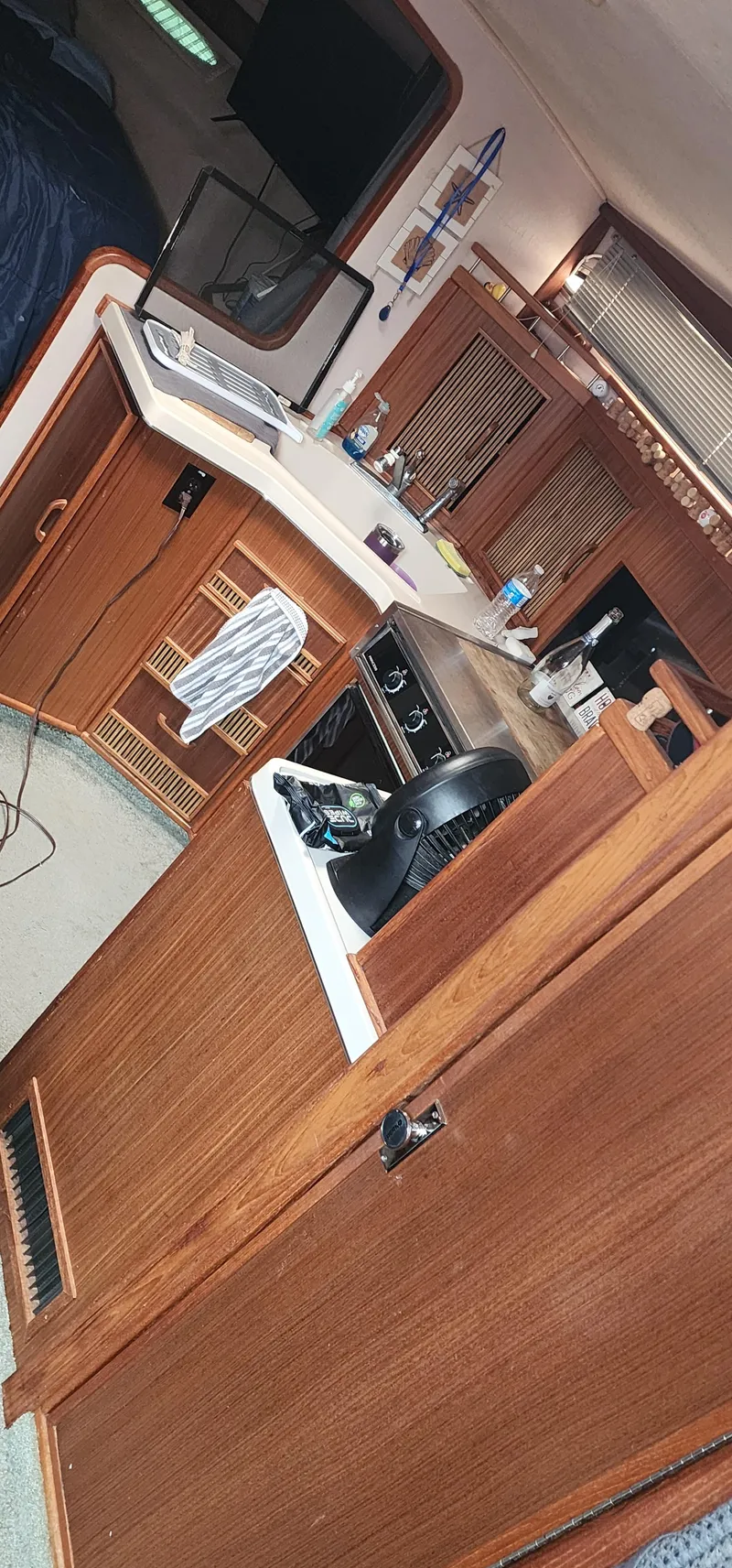 Slide: The Image of 1987 Sea Ray 36 Sundancer interior with wooden cabinetry and kitchen amenities. - 14