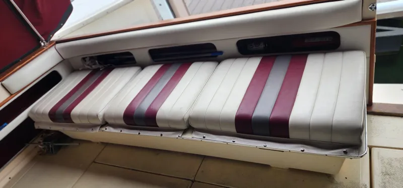 Slide: The Image of 1987 Sea Ray 36 Sundancer boat seating with red and gray striped cushions. - 15