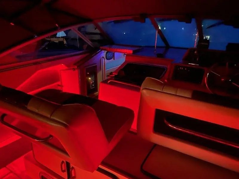 Slide: The Image of 1987 Sea Ray 36 Sundancer interior with red ambient lighting at night. - 16