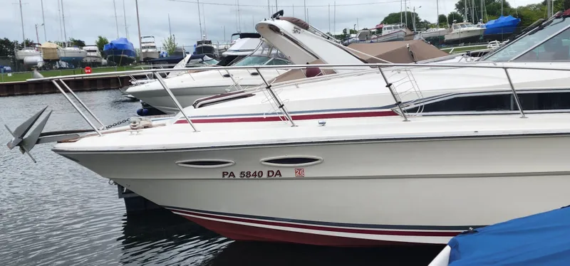 Slide: The Image of 1987 Sea Ray 36 Sundancer docked at marina, side view with visible registration number. - 2