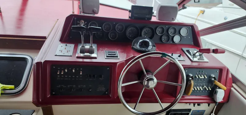 Slide: The Image of 1987 Sea Ray 36 Sundancer helm with red dashboard, steering wheel, and control panels. - 3