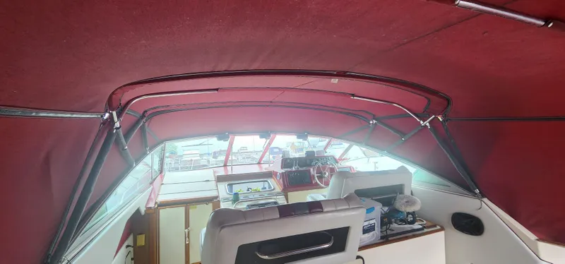Slide: The Image of Interior view of 1987 Sea Ray 36 Sundancer boat with red canopy and helm. - 36