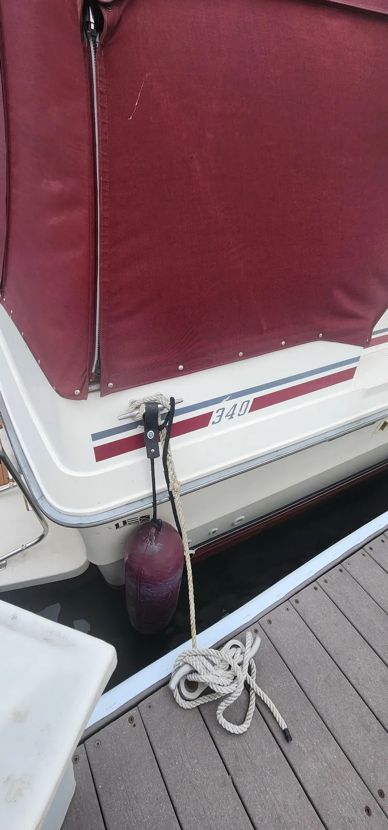 Slide: The Image of 1987 Sea Ray 36 Sundancer docked, featuring maroon cover and fender. - 40
