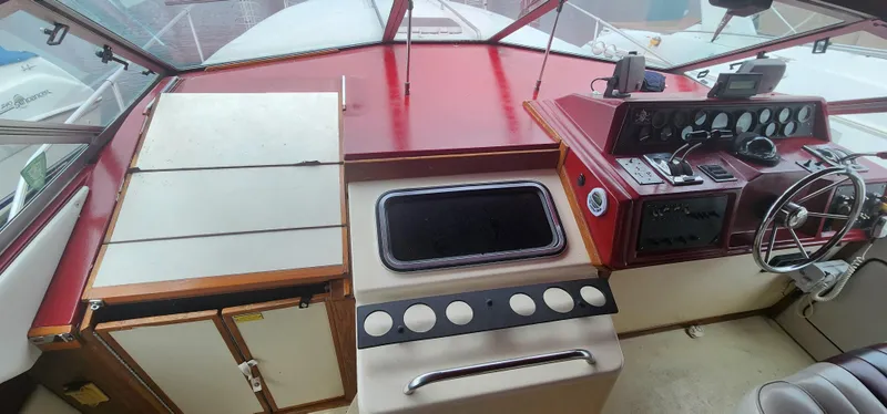 Slide: The Image of 1987 Sea Ray 36 Sundancer helm with red dashboard and steering wheel. - 5