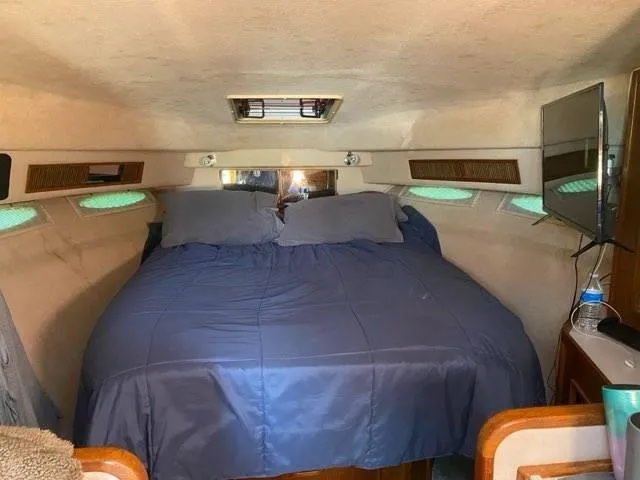 Slide: The Image of Cozy cabin interior of 1987 Sea Ray 36 Sundancer with blue bedding and natural light. - 9