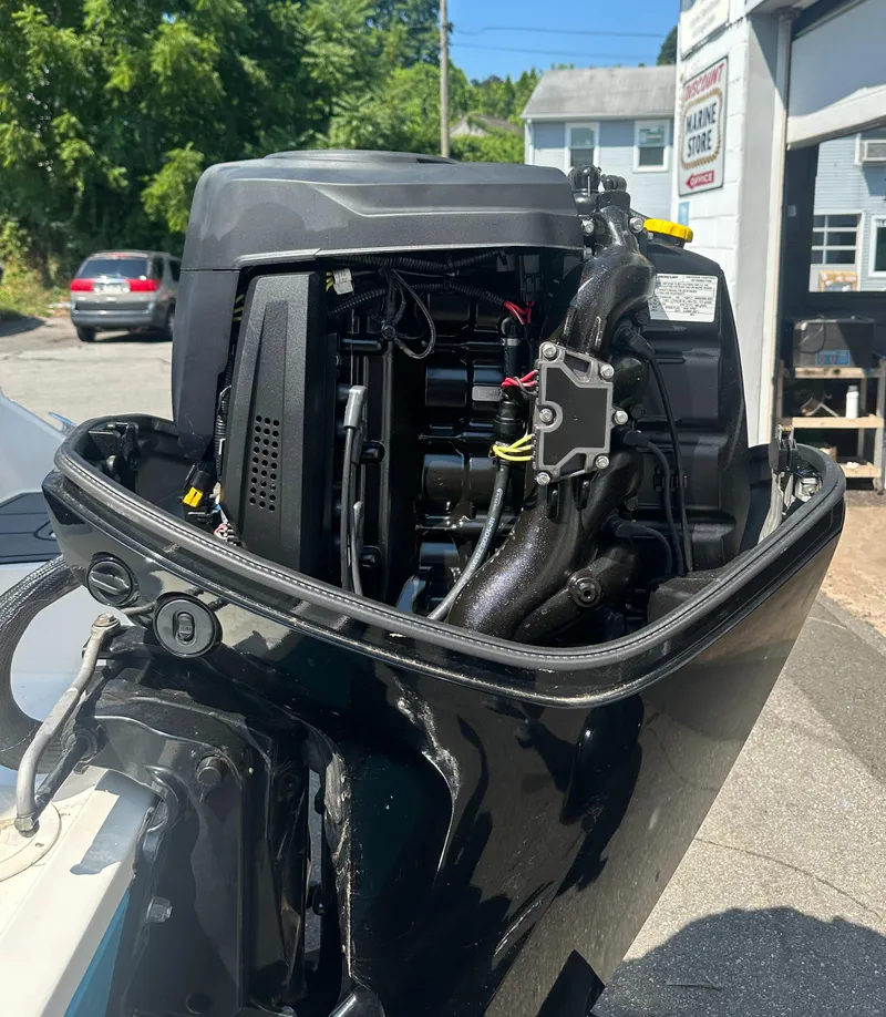 Slide: The Image of Close-up of a 2022 Bayliner Element M17 boat engine in a sunny outdoor setting. - 14