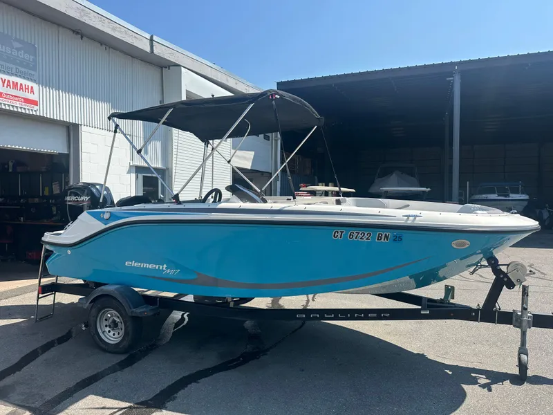 Slide: The Image of 2022 Bayliner Element M17 boat on trailer, parked outside a dealership. - 3